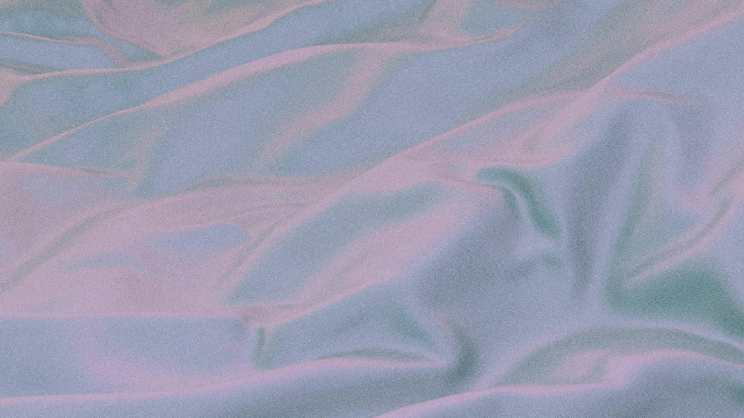 #A close-up of a pastel-colored fabric with smooth, flowing folds, showcasing the soft texture and gentle sheen of the material